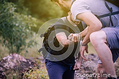 Close up of hand man getting help to bestfriends climb a rock,Helping hands,Overcoming obstacle concept Stock Photo