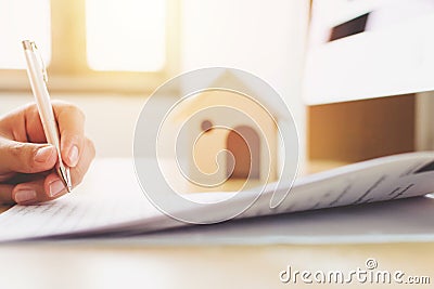 Close up hand of man signing loan document to home ownership. Mortgage and real estate property investment Stock Photo