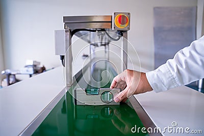 Close up of hand Mechanic technician worker use a water level meter working and Assemble the product sorting machine conveyer in Stock Photo