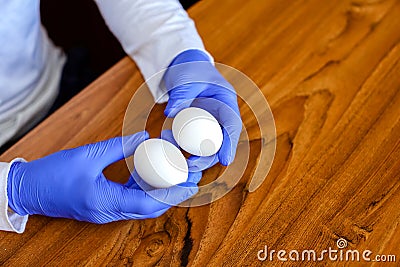 Chicken eggs in gloved hands Stock Photo