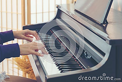 Close up hand playing the piano. Teen Woman relaxing and playing the piano in the livingroom. Stock Photo