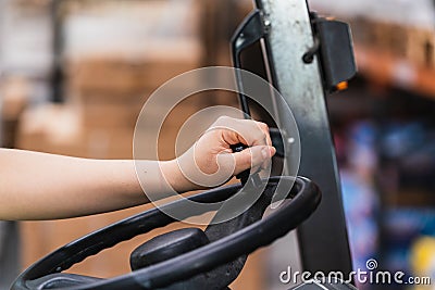 Close-up of a hand on the steering wheel of a forklift Stock Photo