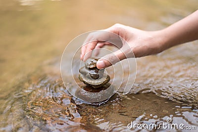 Close up hand to doing Stone stacked in water river Stock Photo