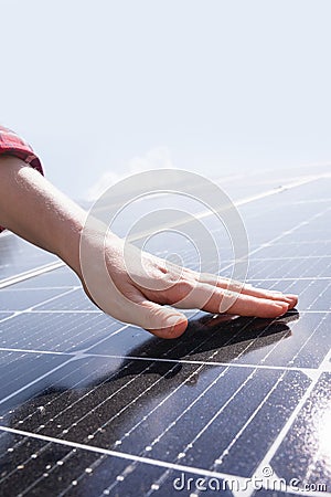 Close-up of a hand touching a solar panel Stock Photo