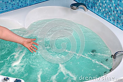Close-up of a hand touching the water in the jacuzzi. Stock Photo