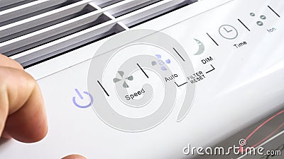 Close up of hand turning ON air filter. Portable air purifier for allergies Stock Photo