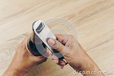 Hand using a stainless steel bottle opener Stock Photo