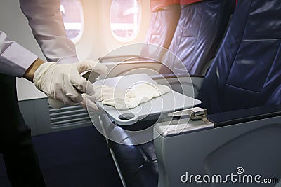 Close up hand is wearing gloves cleaning aircraft seat for covid-19 prevention pandemic Stock Photo