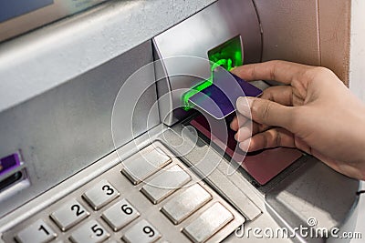 Close up hand of woman using credit card to withdraw money from atm bank machine Stock Photo