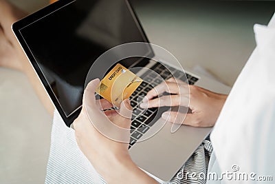 Close up hand of women are buying online with a credit card. woman are using laptop and doing online transactions Stock Photo