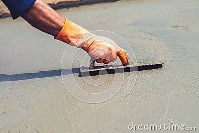 close up hand worker leveling concrete pavement for mix cement a Stock Photo