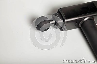 Close up handheld wireless professional therapeutic percussion massager on gray background Stock Photo