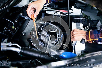 Close up hands checking lube oil level of car engine from deep-stick for service and maintenance concept Stock Photo
