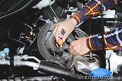 Close up hands checking lube oil level of car engine from deep-stick for service and maintenance concept Stock Photo