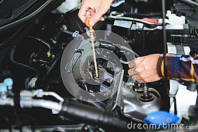 Close up hands checking lube oil level of car engine from deep-stick for service and maintenance concept Stock Photo