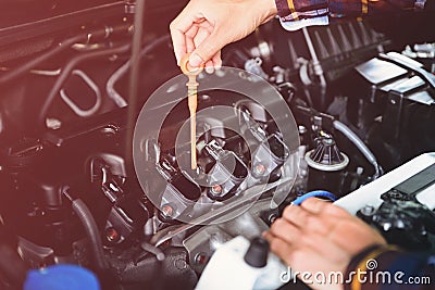 Close up hands checking lube oil level of car engine from deep-stick for service and maintenance concept vintage tone Stock Photo