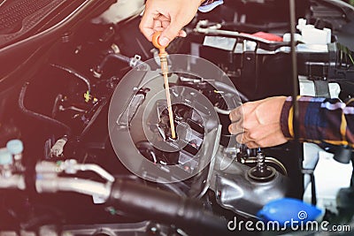 Close up hands checking lube oil level of car engine from deep-stick for service and maintenance concept vintage tone Stock Photo