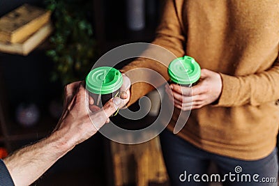 Close up of hands with coffee. Barman giving a freshly brewed fragrant cappuccino with high milk froth in a transparent glass to Stock Photo