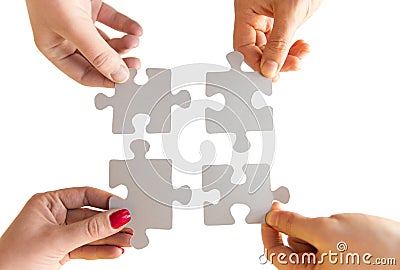 Close up of hands connecting puzzle pieces Stock Photo