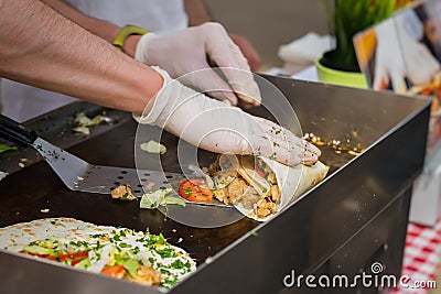 Close-up of hands of cook in gloves preparing fajitas or fajitos. Healthy fresh tortillas with grilled chicken fillet Stock Photo