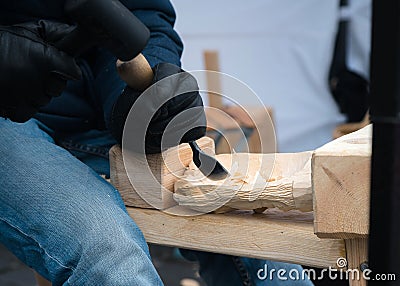 Close up of hands of craftsman carve with a gouge in the hands on the workbench in carpentry Stock Photo