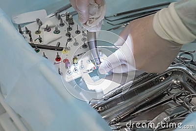 Close-up of the hands of a dentist surgeon on implantation, with dental instrument and surgical template Stock Photo