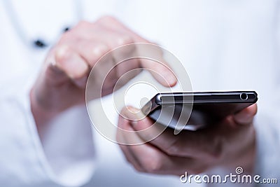 Close-up of hands of doctor using phone Stock Photo