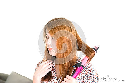 Asian woman brown hair is holding Hair straighteners isolated on white background. Stock Photo