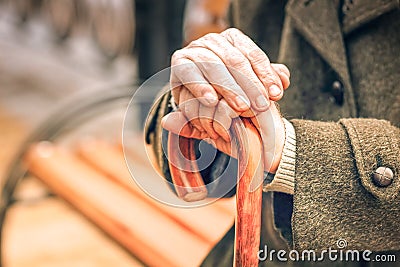 Close up of hands of elderly man leaning on cane Stock Photo
