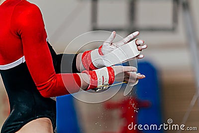 close-up hands female gymnast in gymnastics grips in gym chalk Stock Photo