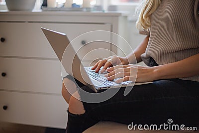 Close-up of the hands of a girl using her laptop sitting indoors. Females using technology concept Stock Photo