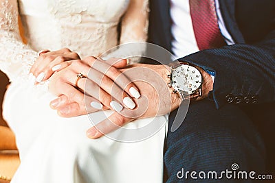 Close-up of the hands of the groom with the clock and the bride Stock Photo