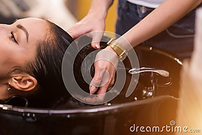 Close up of hands hairdresser washes the client`s hair. Spa, care, beauty and people concept Stock Photo