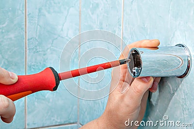 Close-up of hands handyman with screwdriver, install bracket for Stock Photo