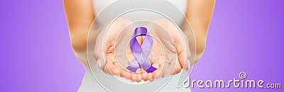 Close up of hands holding purple awareness ribbon Stock Photo