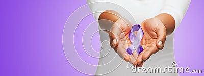 Close up of hands holding purple awareness ribbon Stock Photo