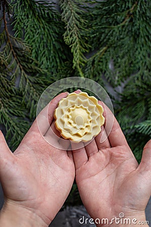 Close-up of hands holding a round solid handmade shampoo. Taking care of health and nature. Stock Photo