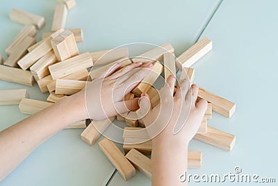 Close-up hands of little boy play with wooden bricks game Stock Photo