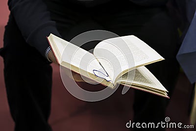 Close-up of hands of man in dark clothes with open book. Real scene in the store. Self-study, education, manuals Stock Photo