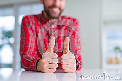 Close up of hands man doing thumbs up gesture over white table Stock Photo