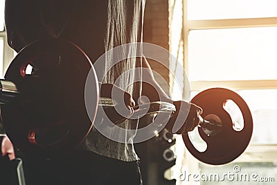 Close-up of the hands of a muscular man performs exercises with a barbell in the gym. Endurance Strength Training Stock Photo