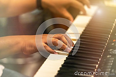 Close up hands of pianist musician playing keyboard synthesizer on band in night concert Stock Photo