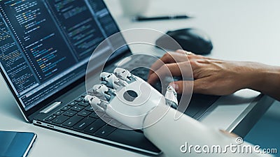 Close-up on Hands: Programmer With Disability Using Prosthetic Arm to Work on Laptop Computer Stock Photo