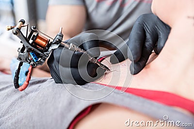 Close-up of the hands of a skilled artist making the contour of a tattoo Stock Photo