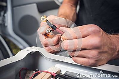 Close up of hands using heat shrink tubing on a cable with a cable lug Stock Photo