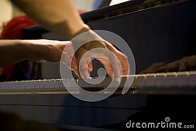 Close-up on the hands of a woman playing the piano with music keys Stock Photo