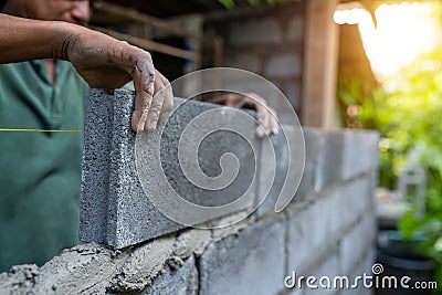 Close-up hands worker use brick block construction Stock Photo