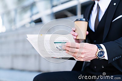 Businessman reading finance news in newspaper with coffee Stock Photo