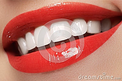 Close-up happy female smile with healthy white teeth, bright red lips make-up. Cosmetology, dentistry and beauty care Stock Photo