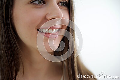 nice young woman is looking up over white background close-up happy girl's face teeth clean white even smile sincere Stock Photo
